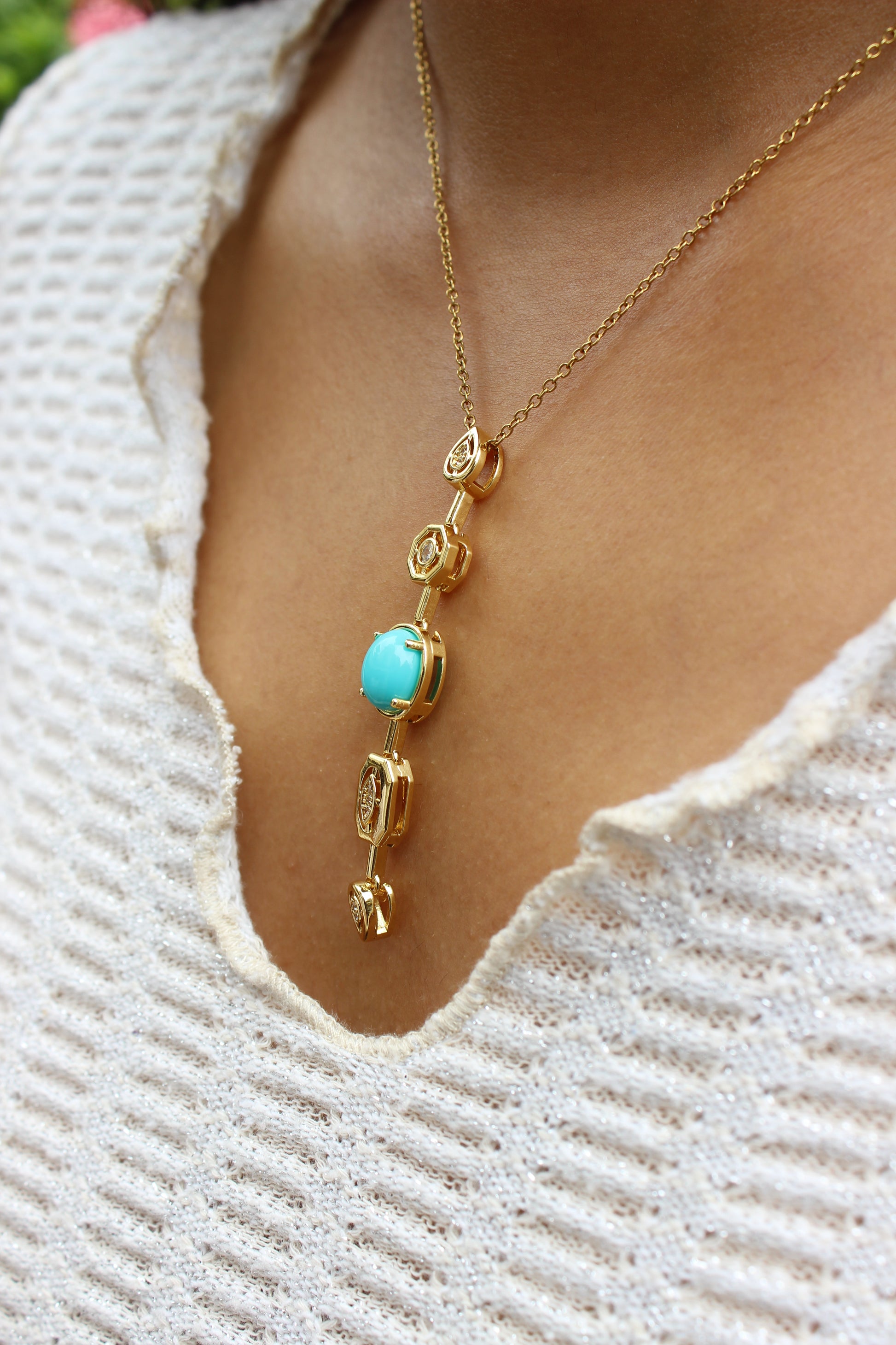 Medina Moon Necklace with a turquoise stone worn by a model against a textured white background