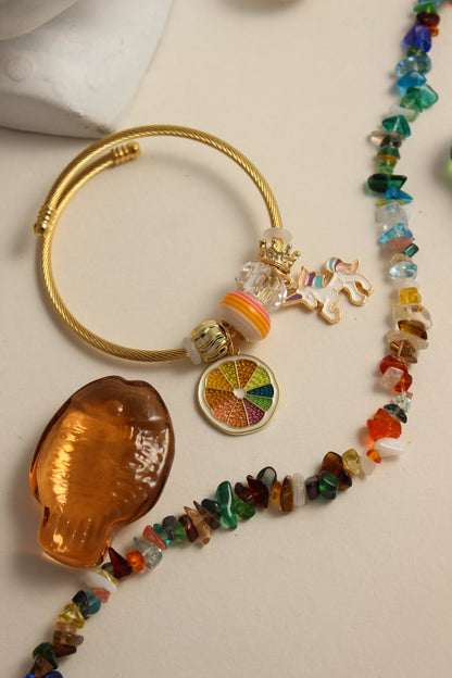 Citrus Carnival Bracelet with colorful beads and decorative charms on a beige surface