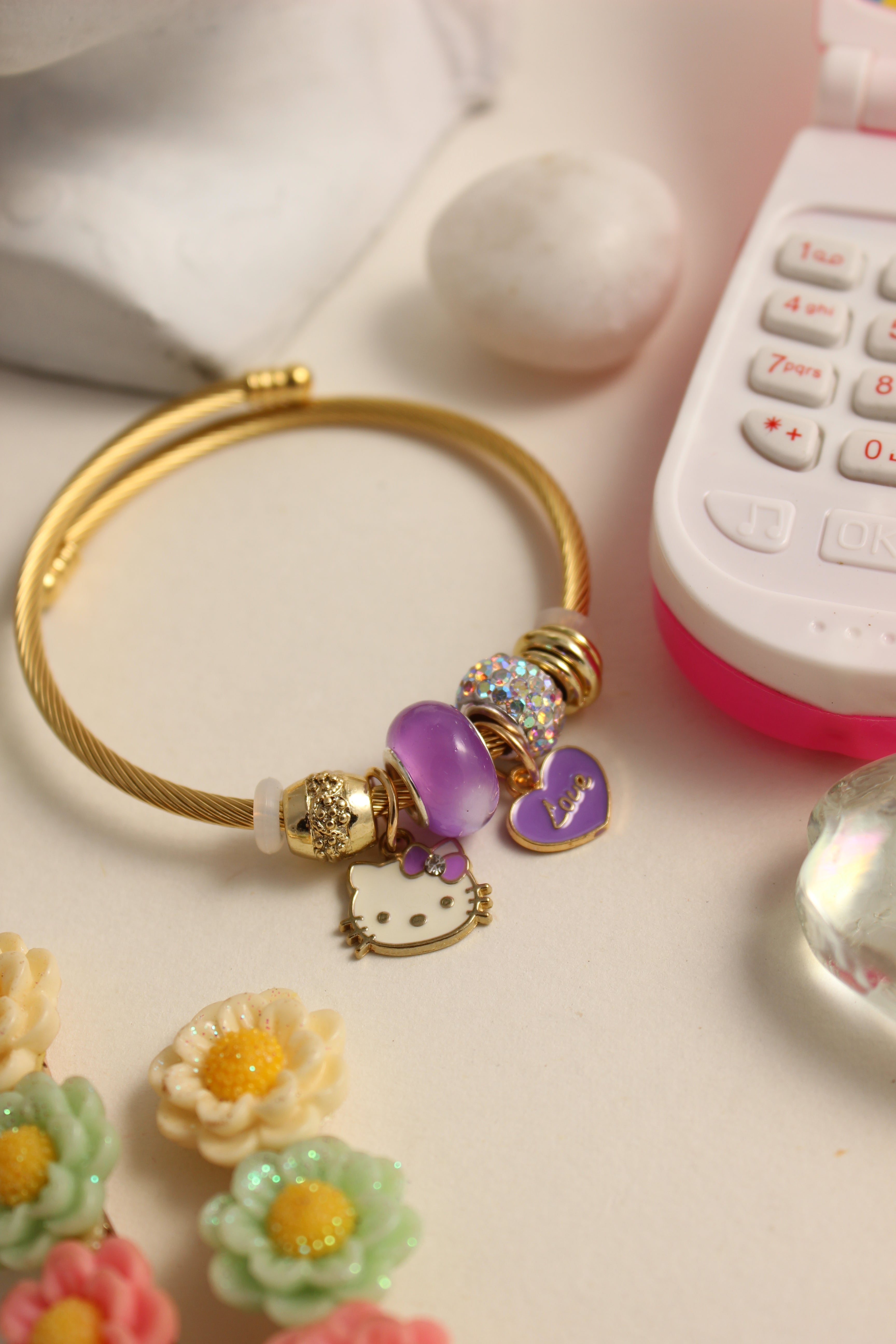 Violet Purr Bracelet on a pink surface with decorative stones