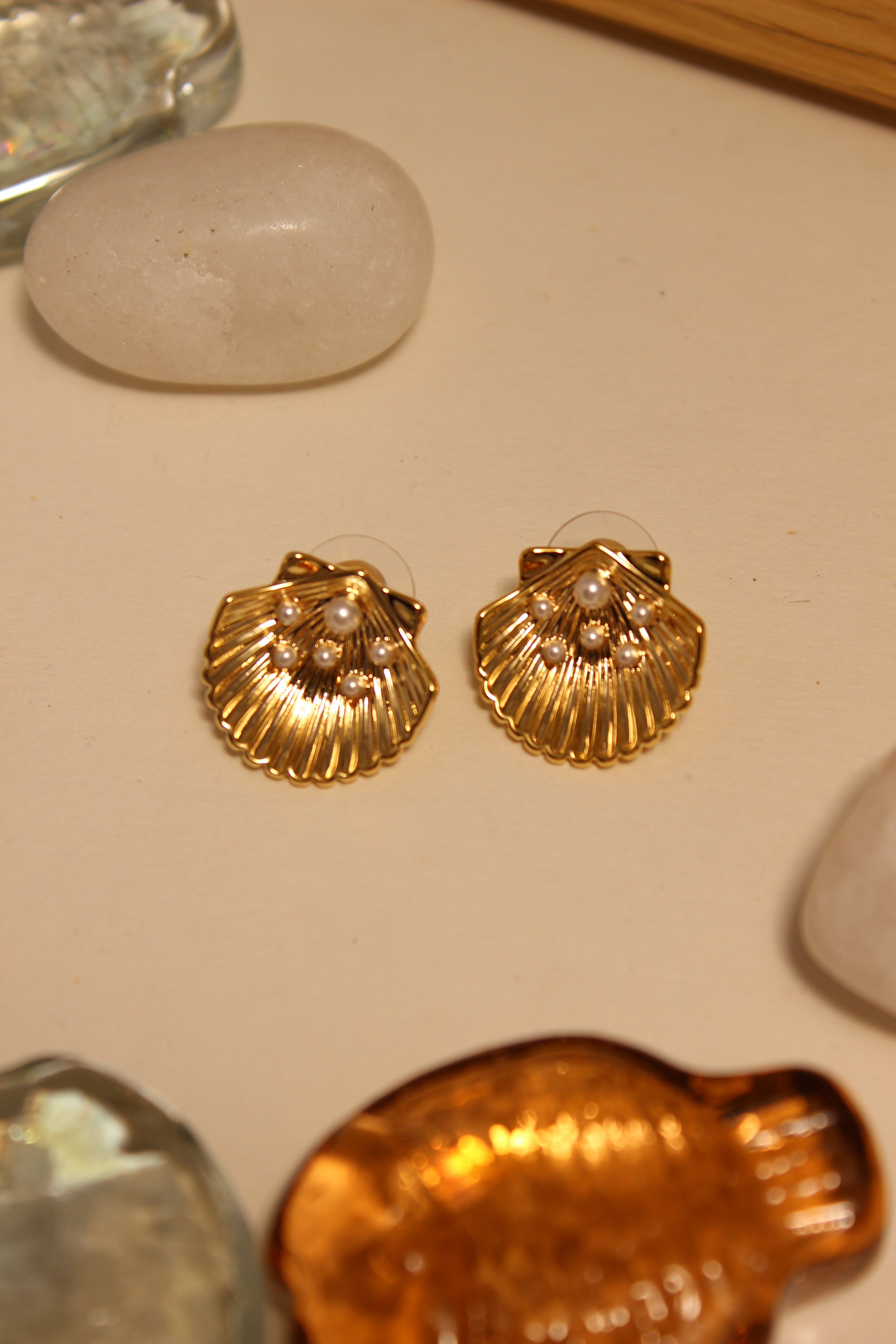 Sunset in Bloom Stud Earrings on a beige surface