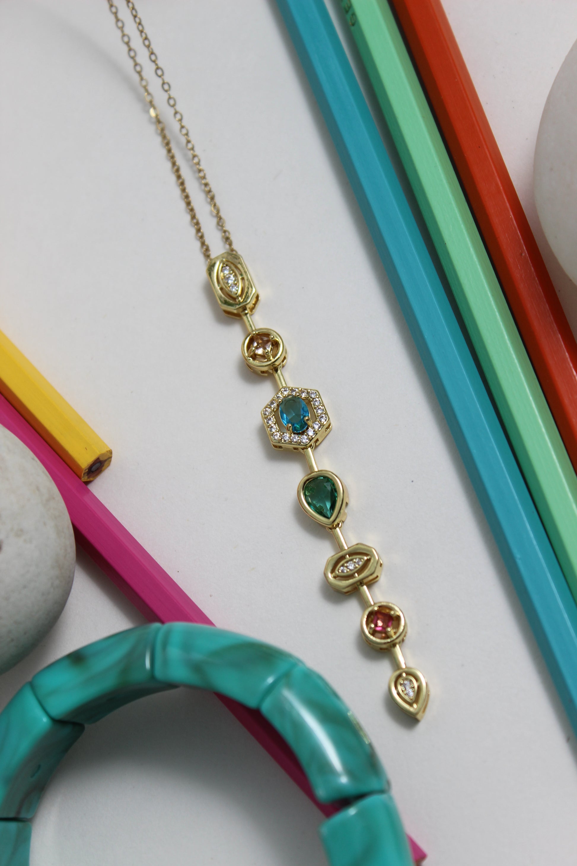 Stellar Pour Necklace with gemstones on a colorful background