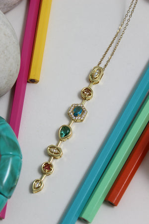 Stellar Pour Necklace with colorful gemstones on a white surface with colorful pencils