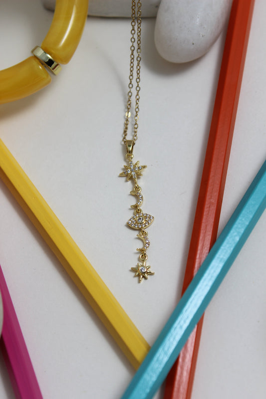 Stellar Sky Necklace on a white surface with colorful pencils and a stone