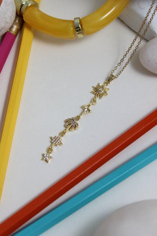 Golden Palm Necklace with star designs on a white surface with colorful pencils