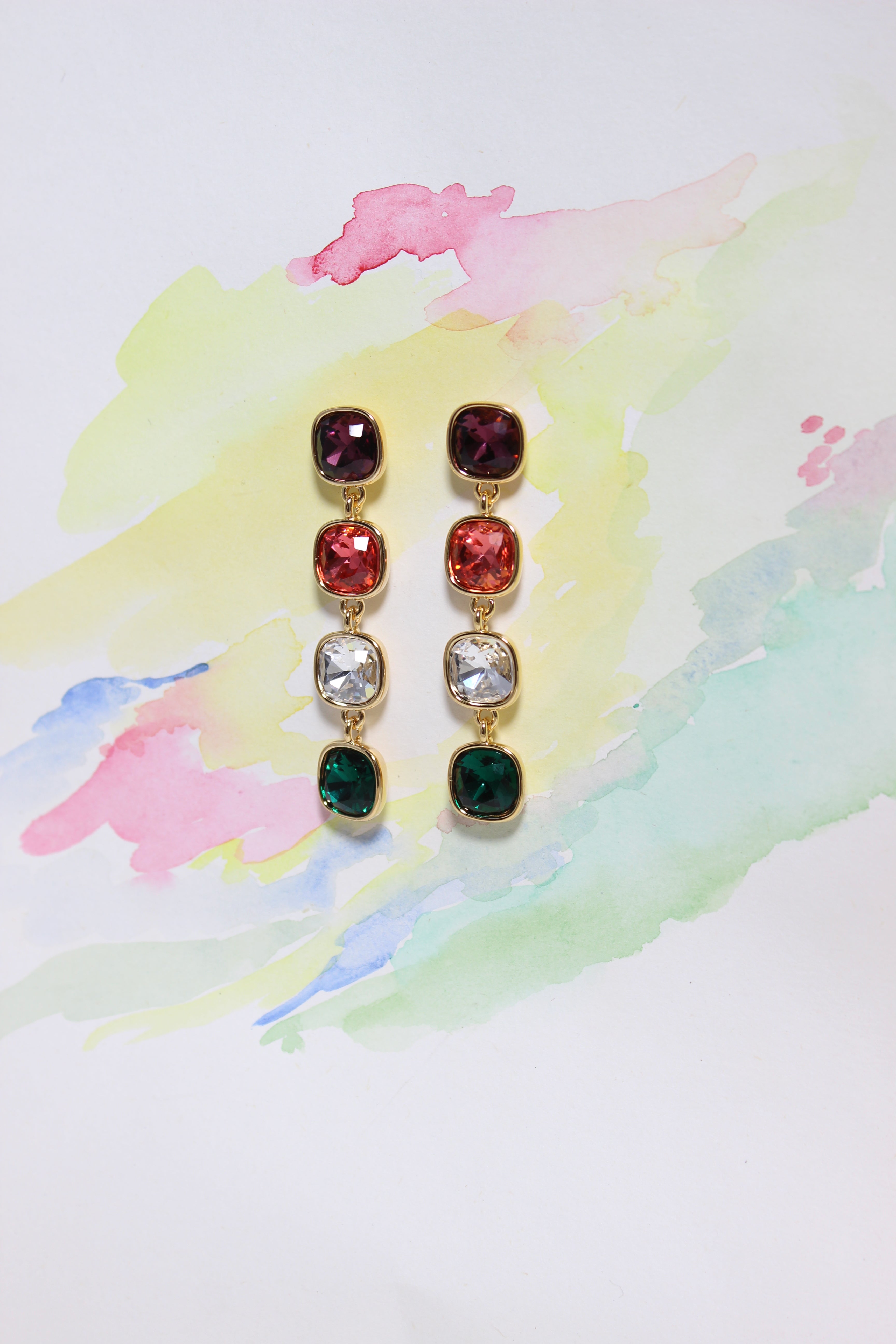 Rosette Meadow Earrings with colorful gemstones on a watercolor background