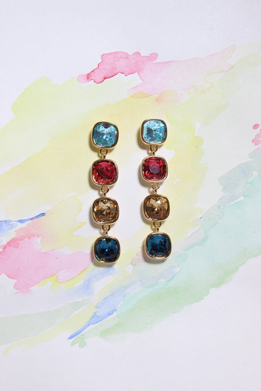 Set of Radiant Skies Earrings with colorful gemstones on a watercolor background