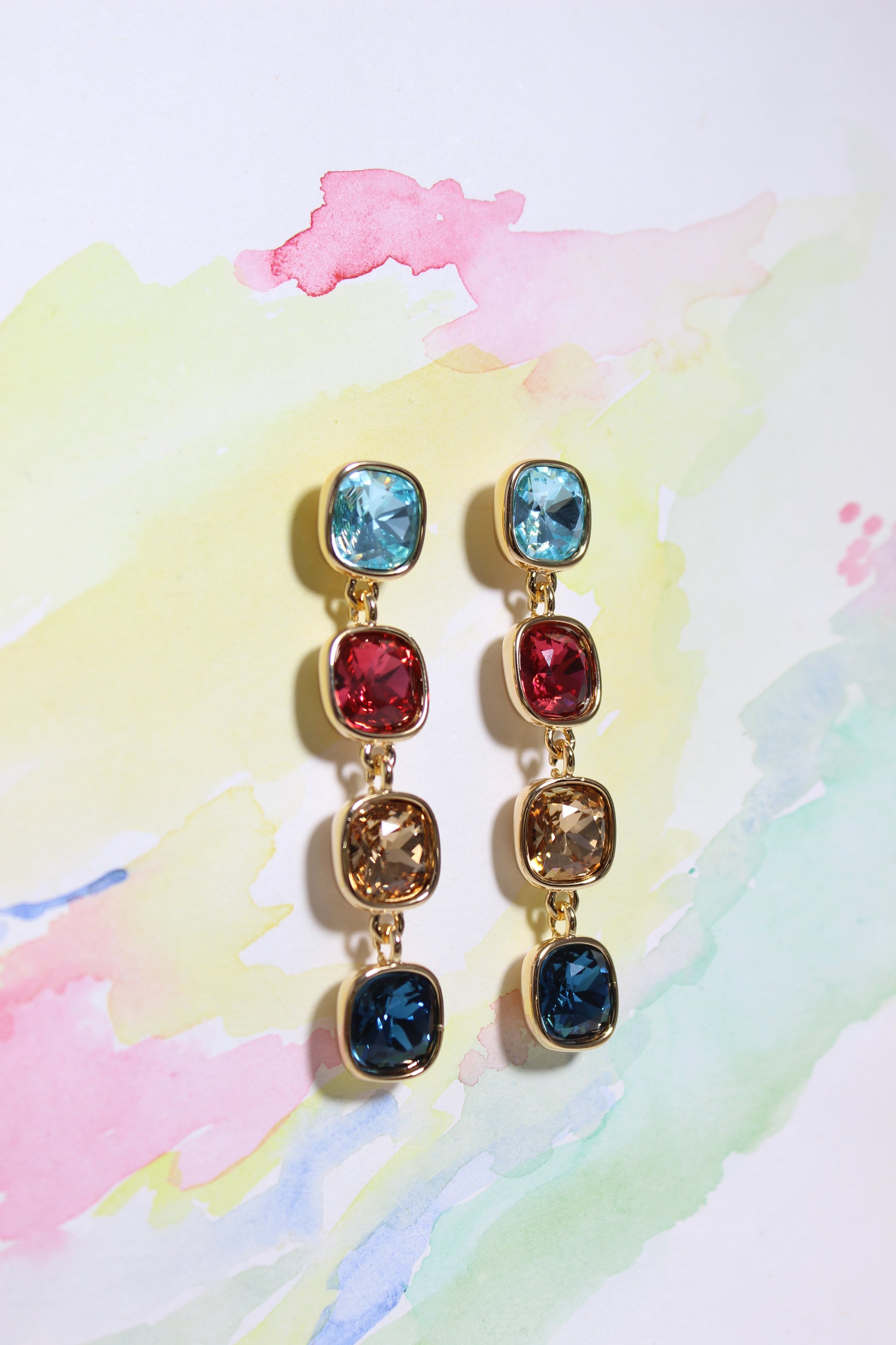 Radiant Skies Earrings on a watercolor background
