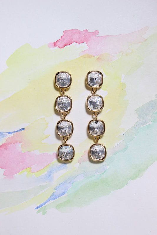 Pair of Glacier Glow Earrings on a colorful watercolor background