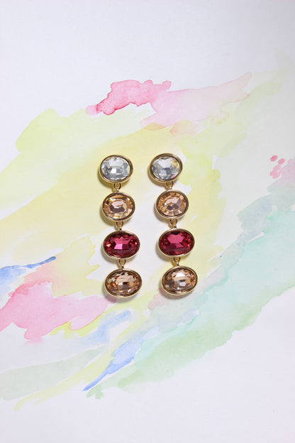Pair of Radiance Veil Earrings with multicolored gemstones on a watercolor background