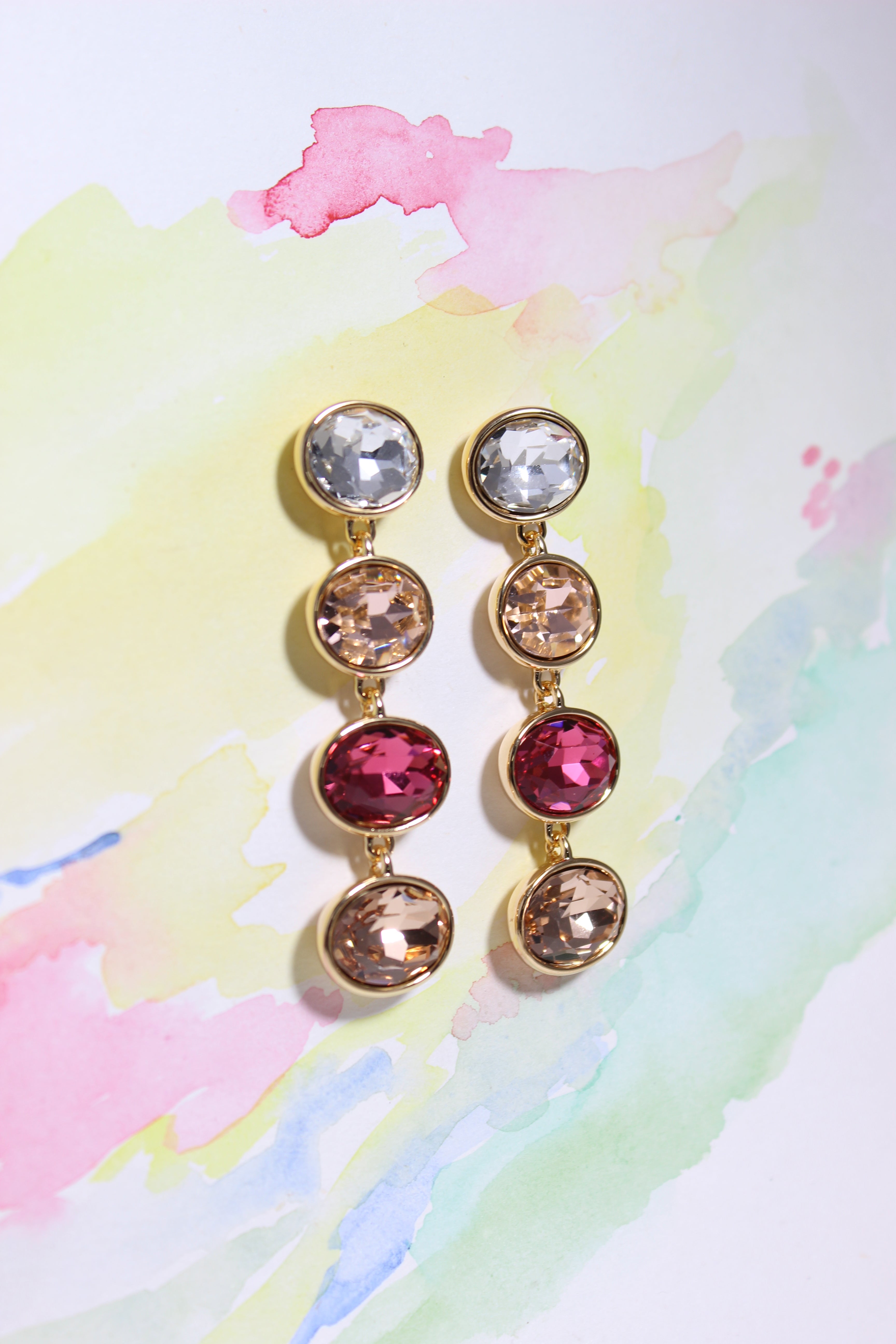 Radiance Veil Earrings on a colorful watercolor background