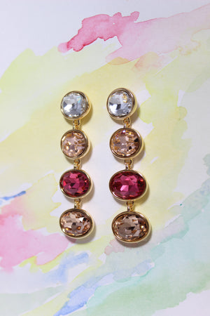 Pair of gold Radiance Veil Earrings with colorful gemstones on a watercolor background