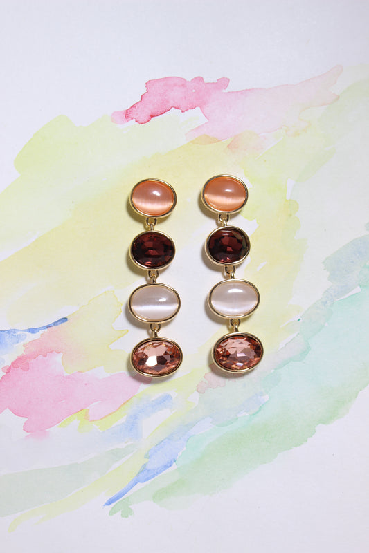 Set of Blush Radiance Earrings with multicolored gemstones on a watercolor background