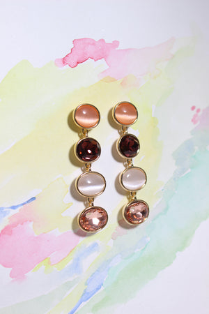 Blush Radiance Earrings on a color background