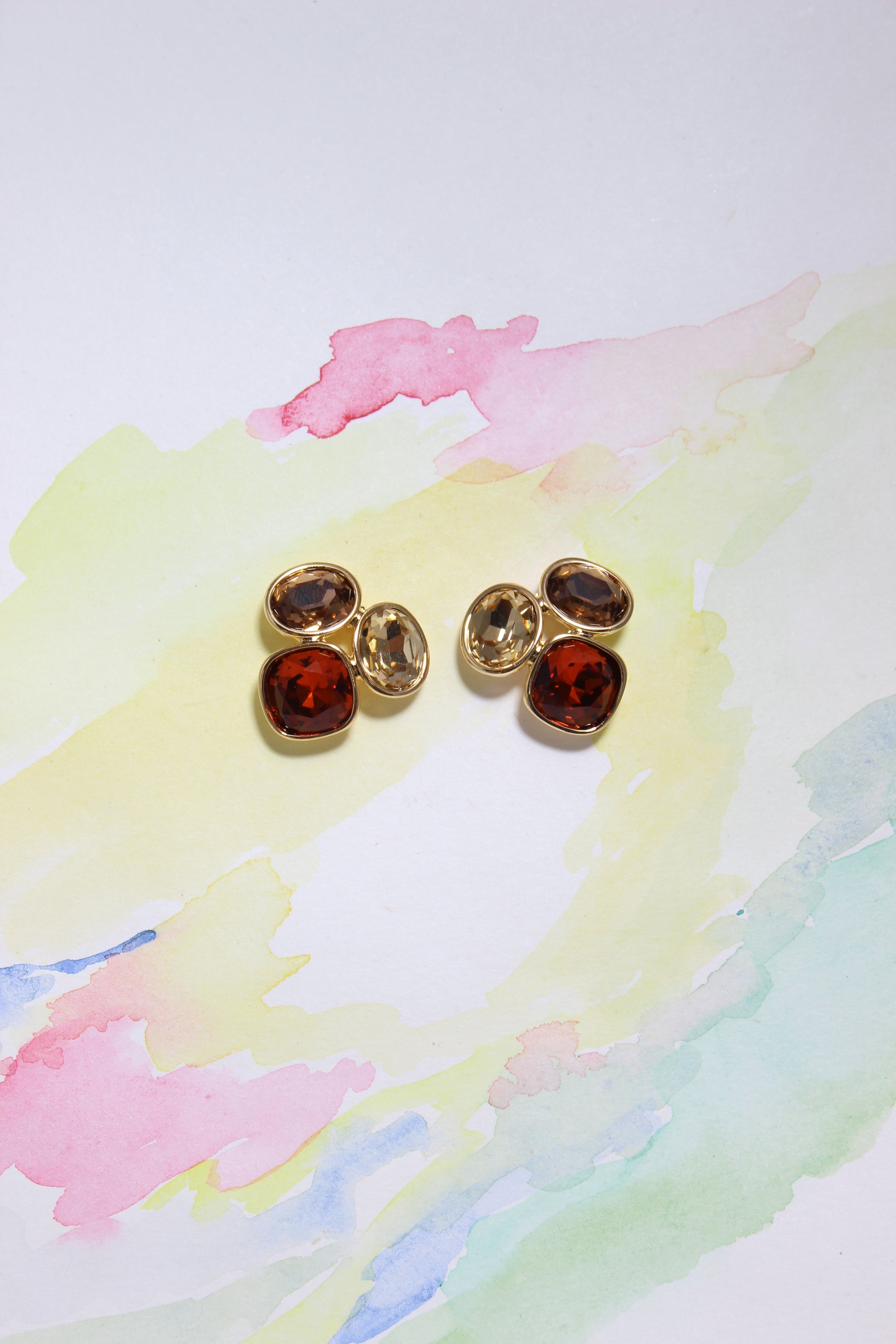 Sunflare Earrings on a colorful watercolor background