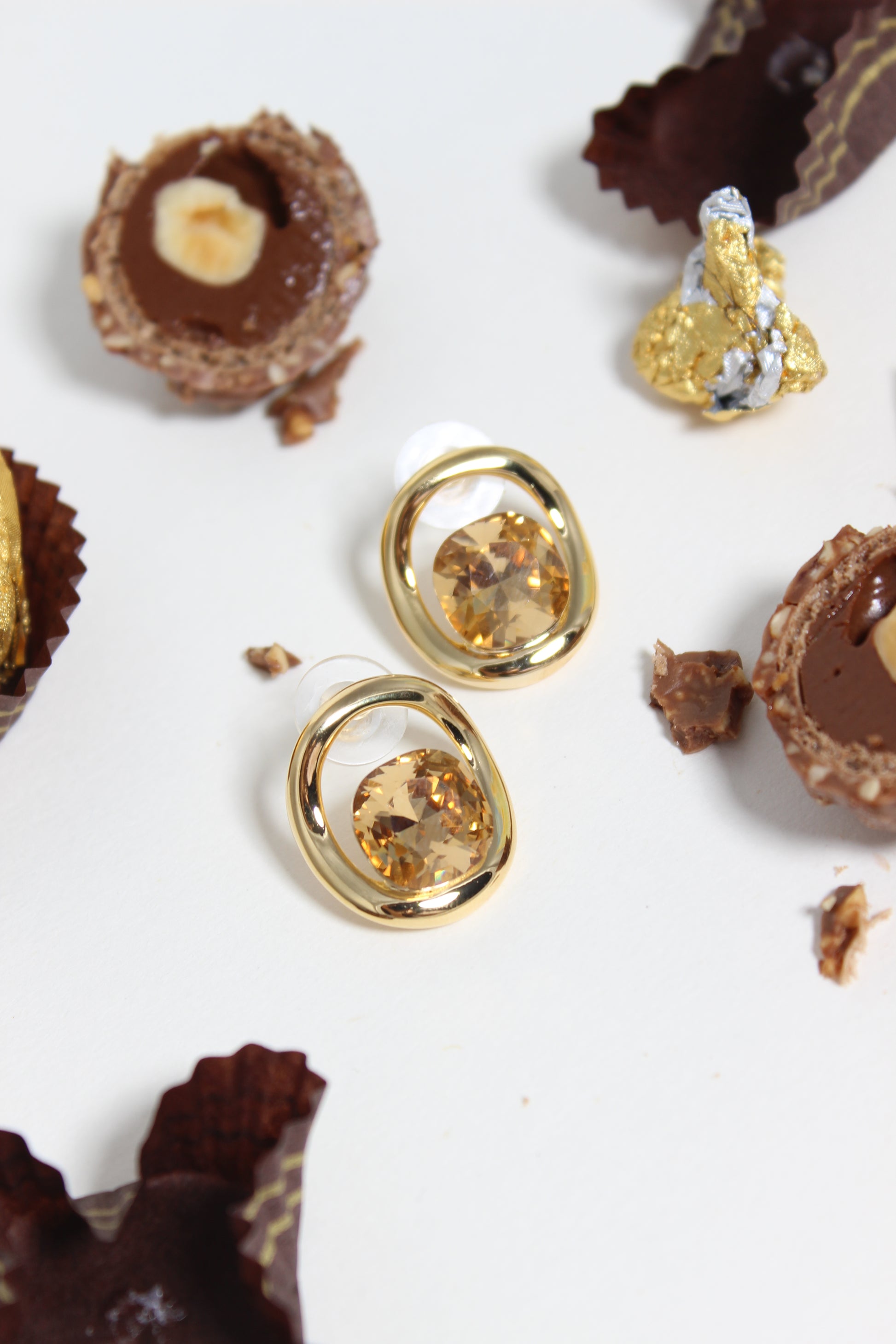 Gold Golden Truffle Earrings with gemstones on a white background with chocolate truffles