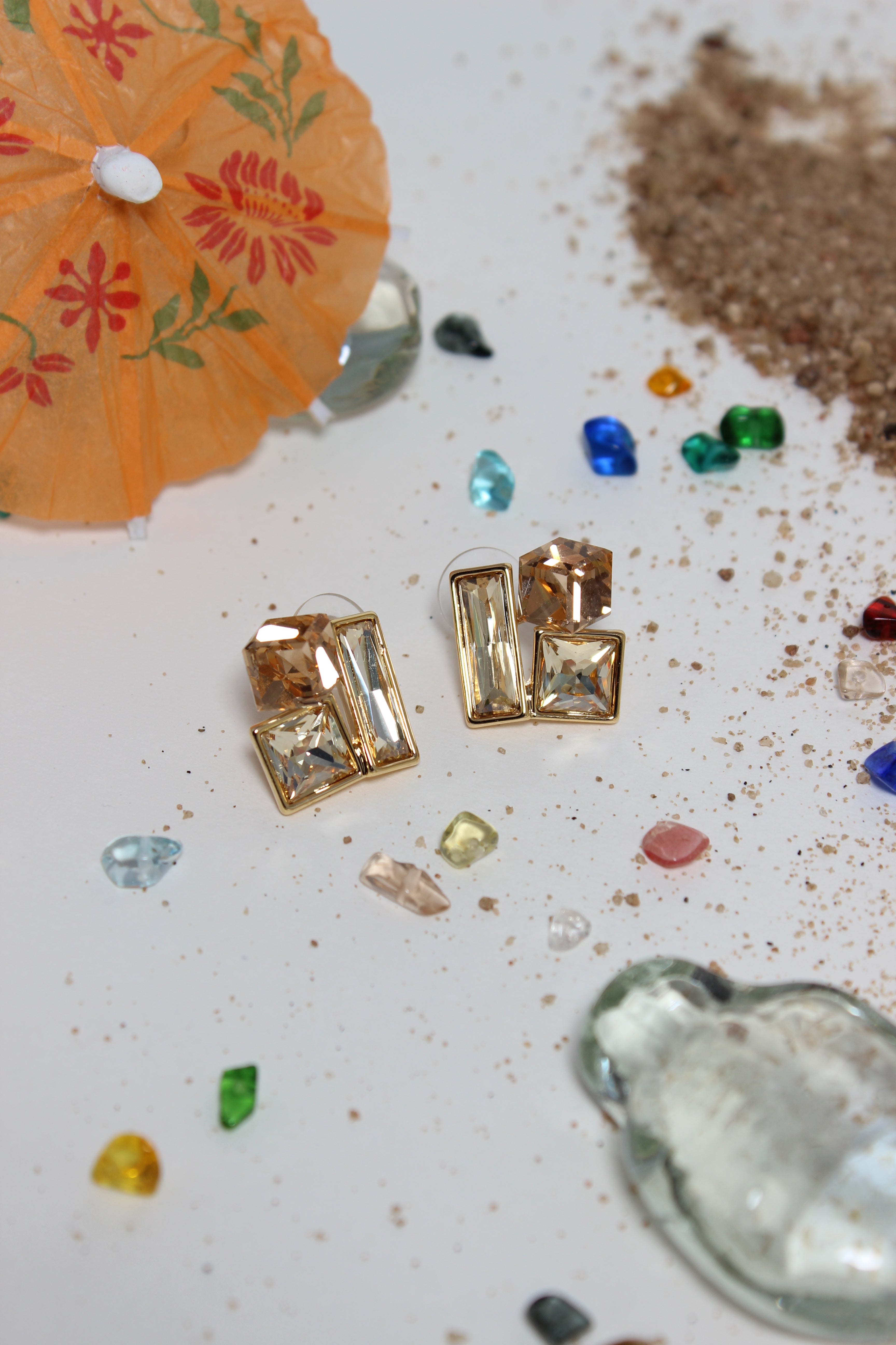 Copper Glow Earrings on a textured surface with seashells