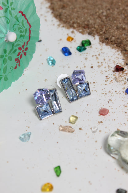 Twilight Glow Earrings on a textured surface with colorful gemstones around