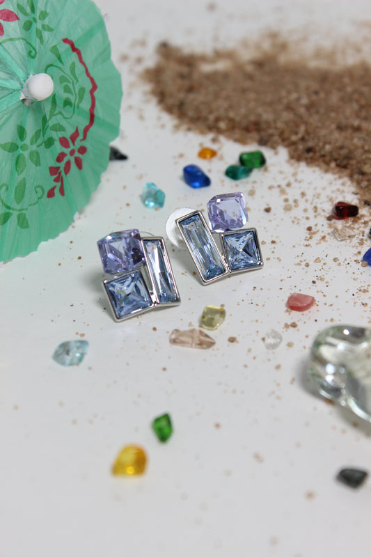 Twilight Glow Earrings on a textured surface with small colored stones
