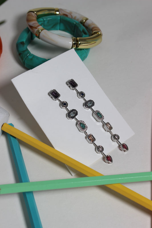 Argent Pastel Pour Earrings on a white card with colorful pencils in the background