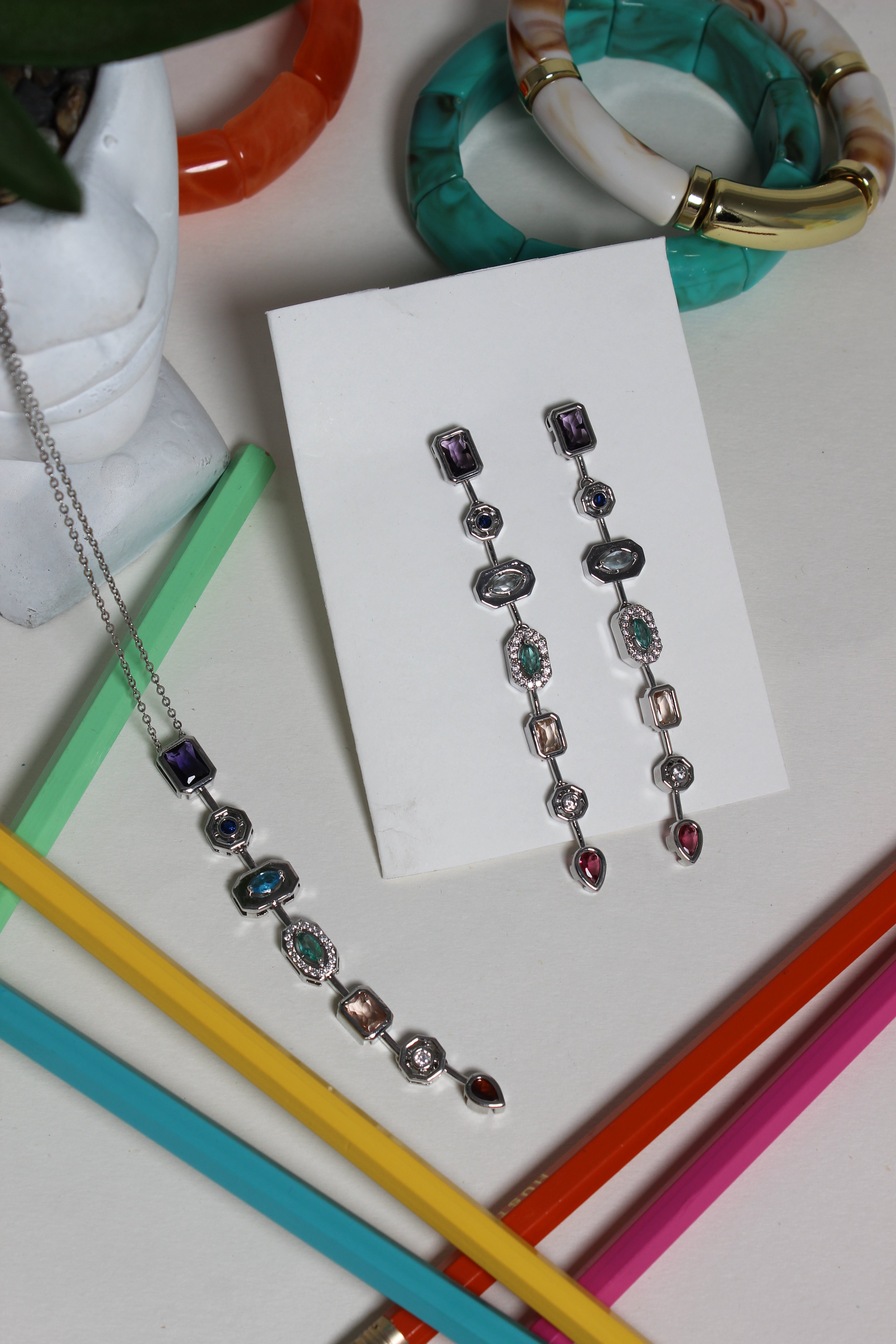 Argent Pastel Pour Earrings on a white card surrounded by colorful straws