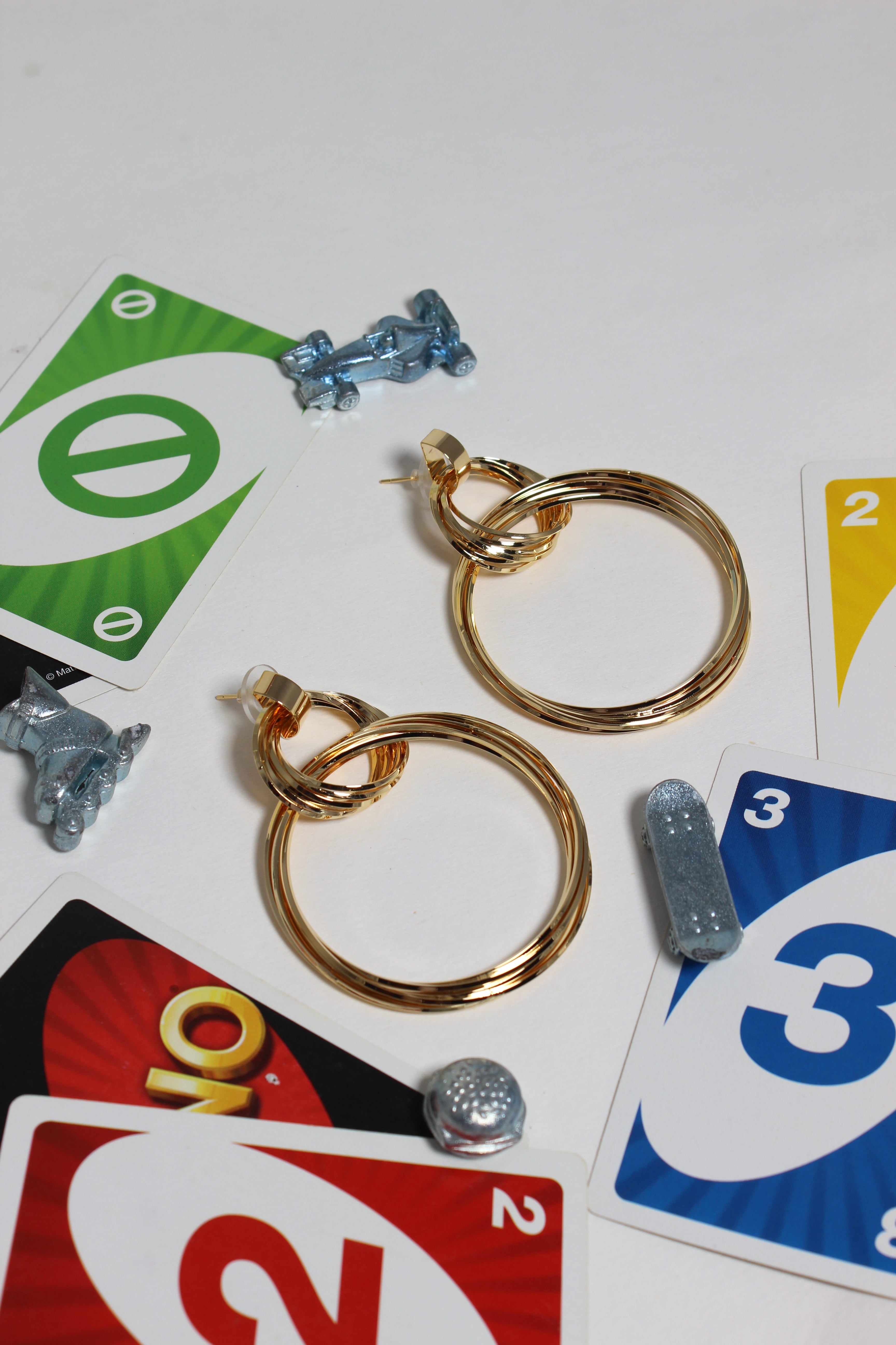 Cosmo Ring Earrings on a white surface with game cards and small figurines