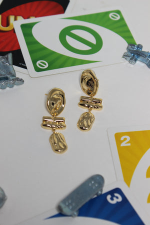 Athena Earrings on a table with playing cards in the background