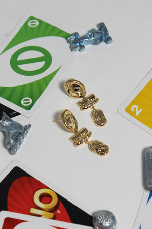 Athena Earrings on a table with playing cards and small decorative cars
