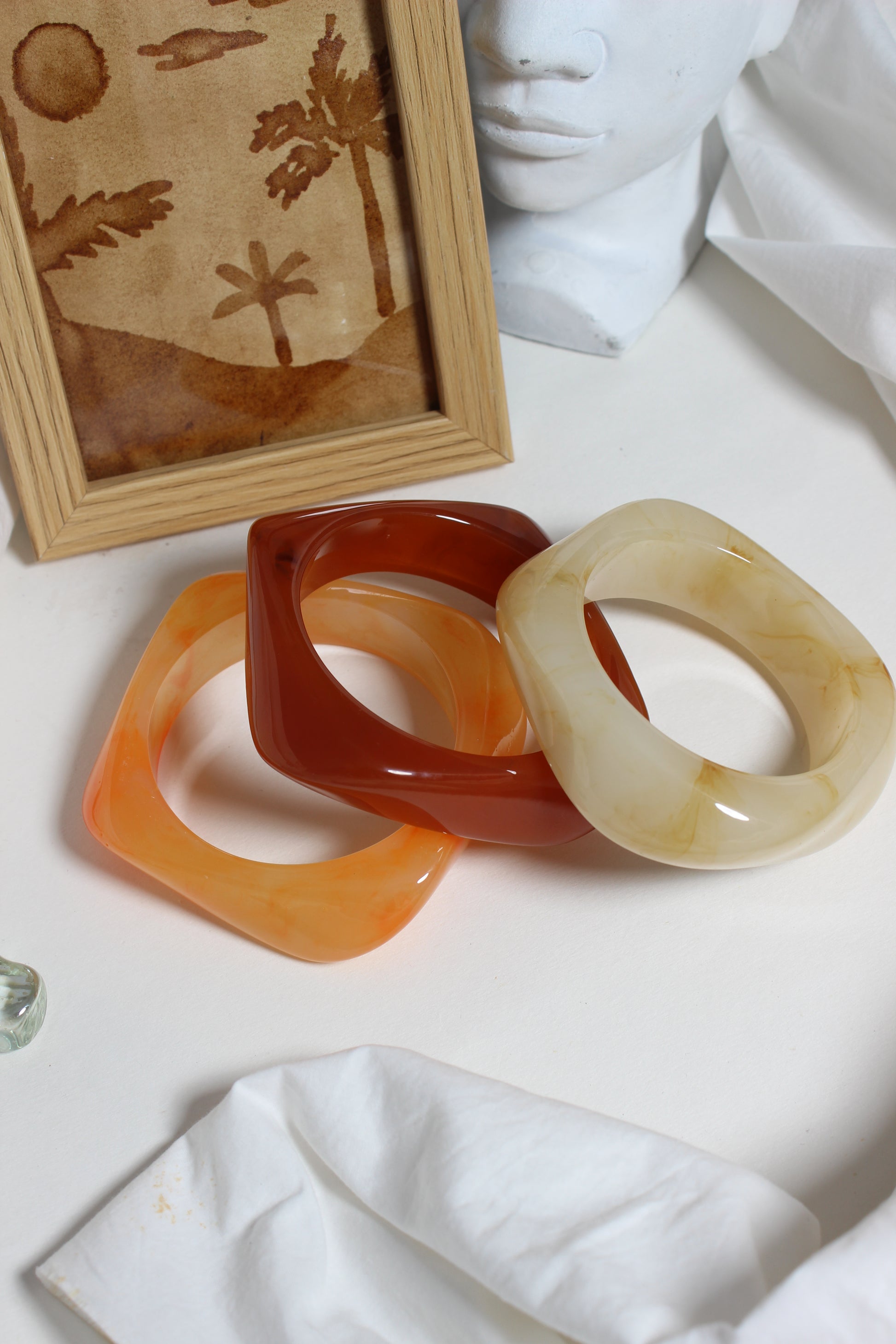 Fizz Resin Bangles on a white surface with a framed artwork