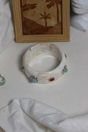Soleil Bangle with colorful stones on a white surface