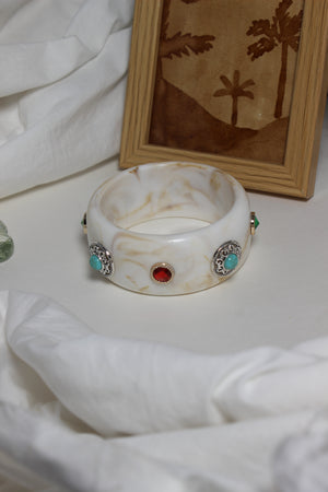 Decorative Soleil Bangle with gemstones on a white surface