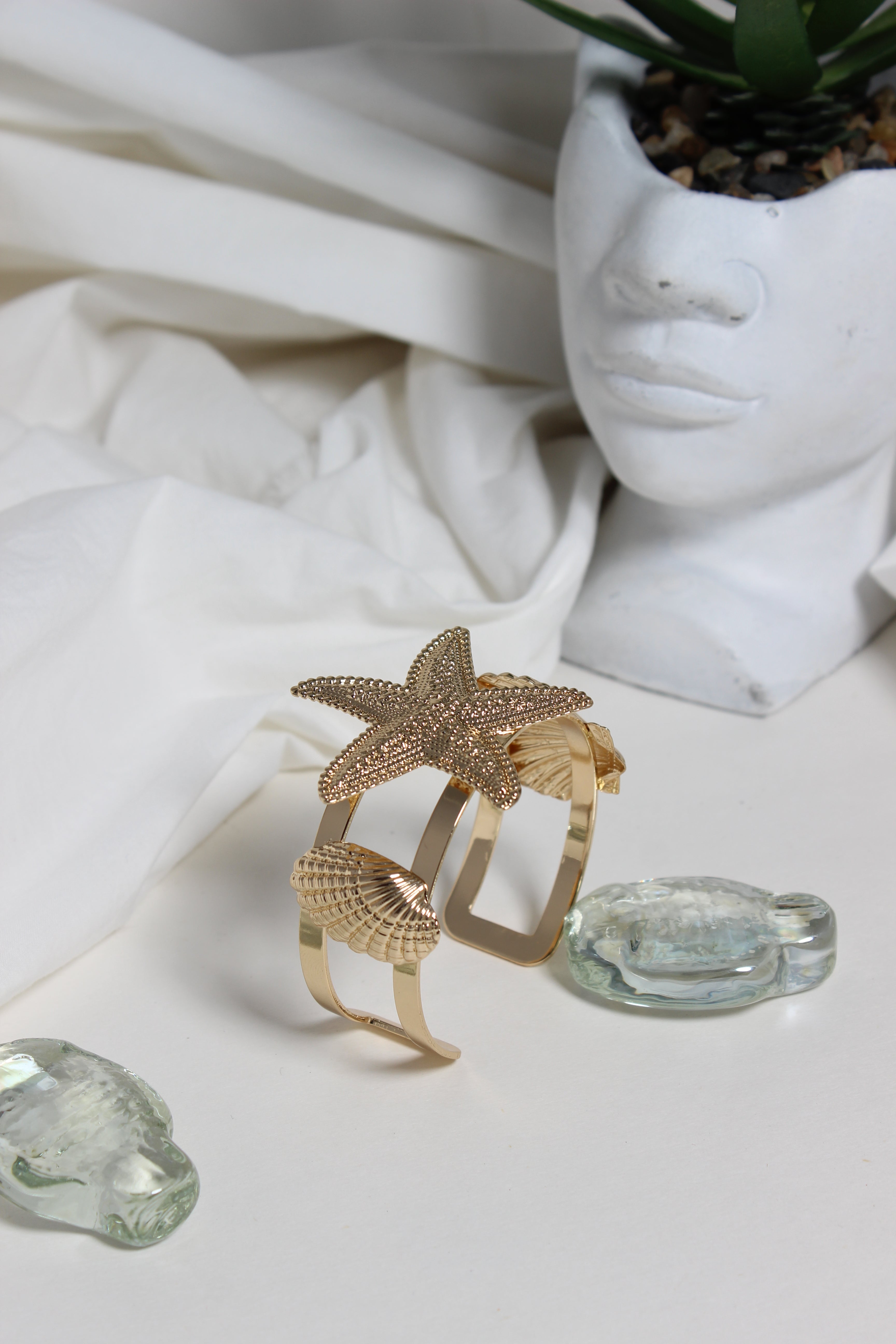 Golden Tide Cuff Bracelet with starfish and shell design on a white surface