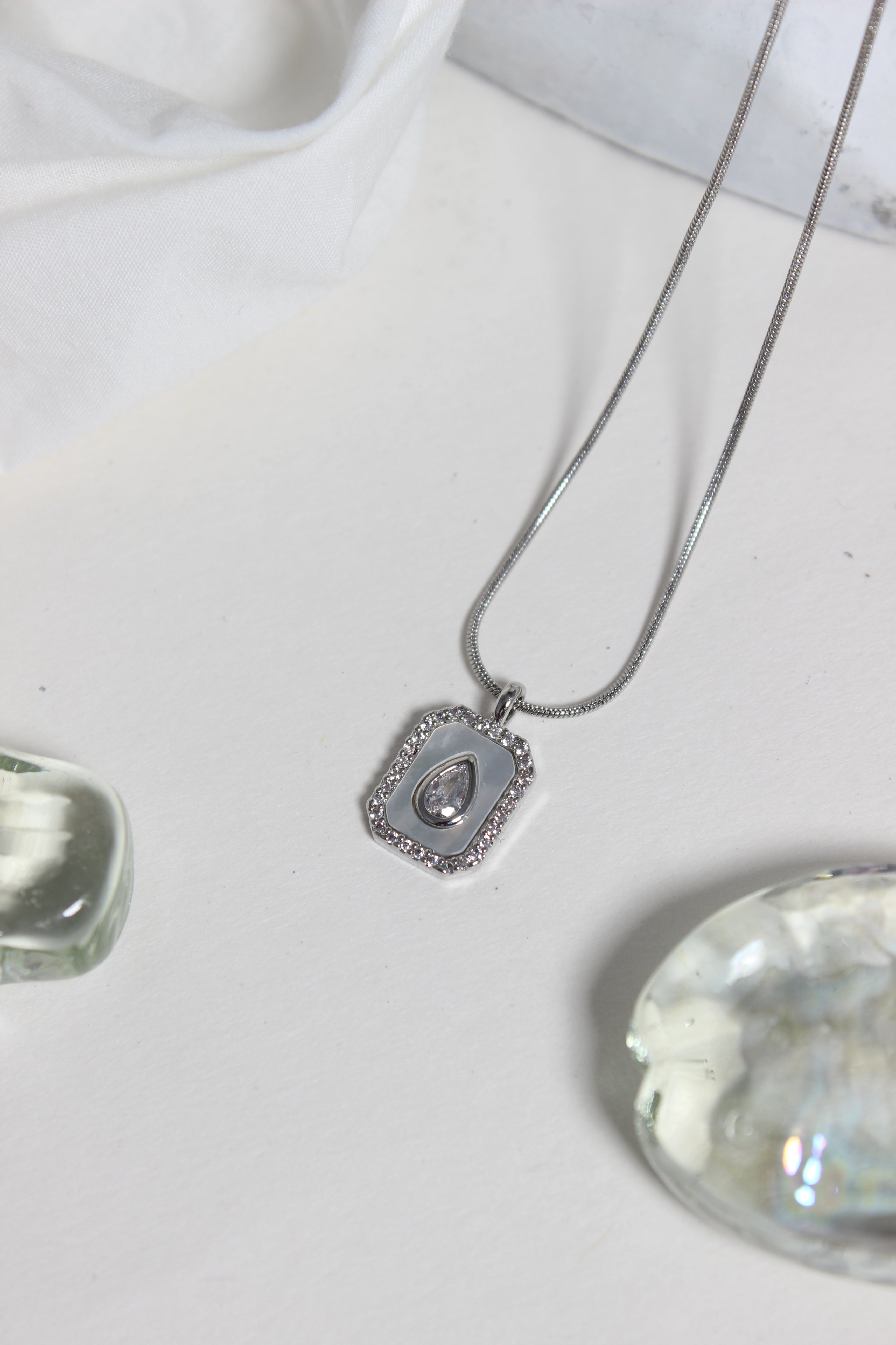 Emeraude Glow Pendant Necklace on a white surface