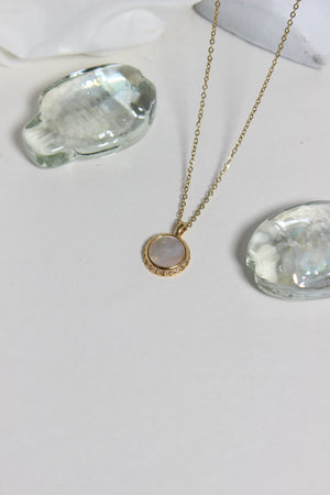 Iridesca Pendant Necklace on a white white surface 