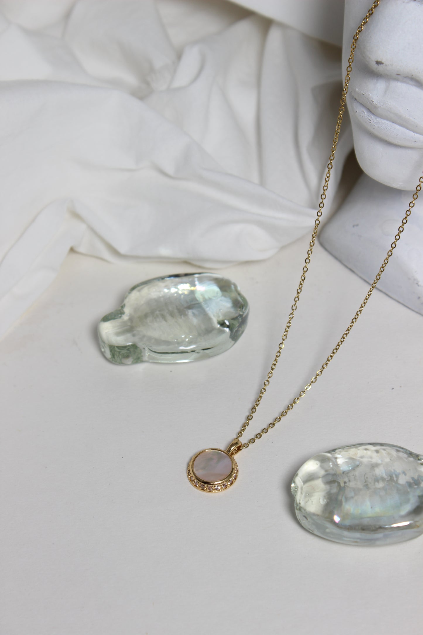 Iridesca Pendant Necklace with a marble bust in the background