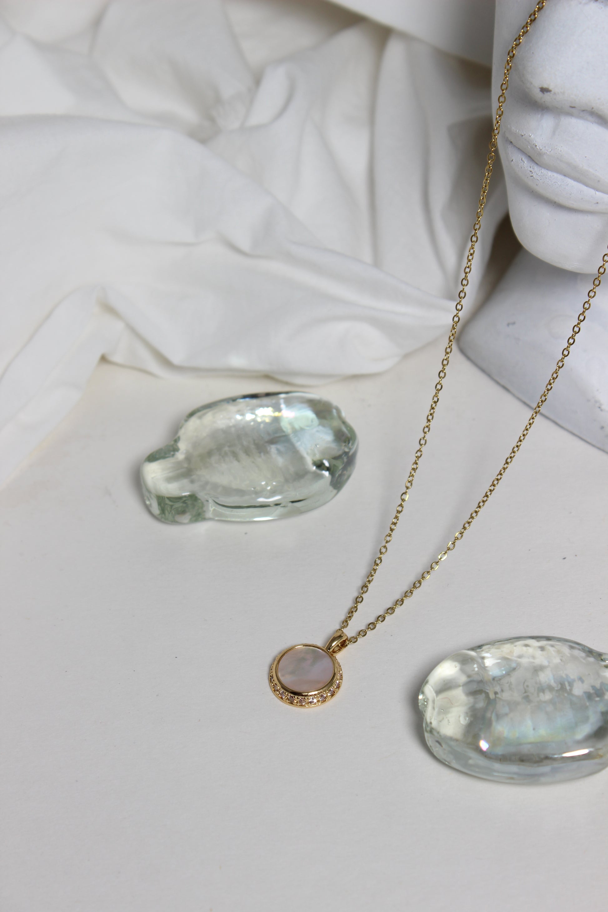 Iridesca Pendant Necklace with a marble bust in the background