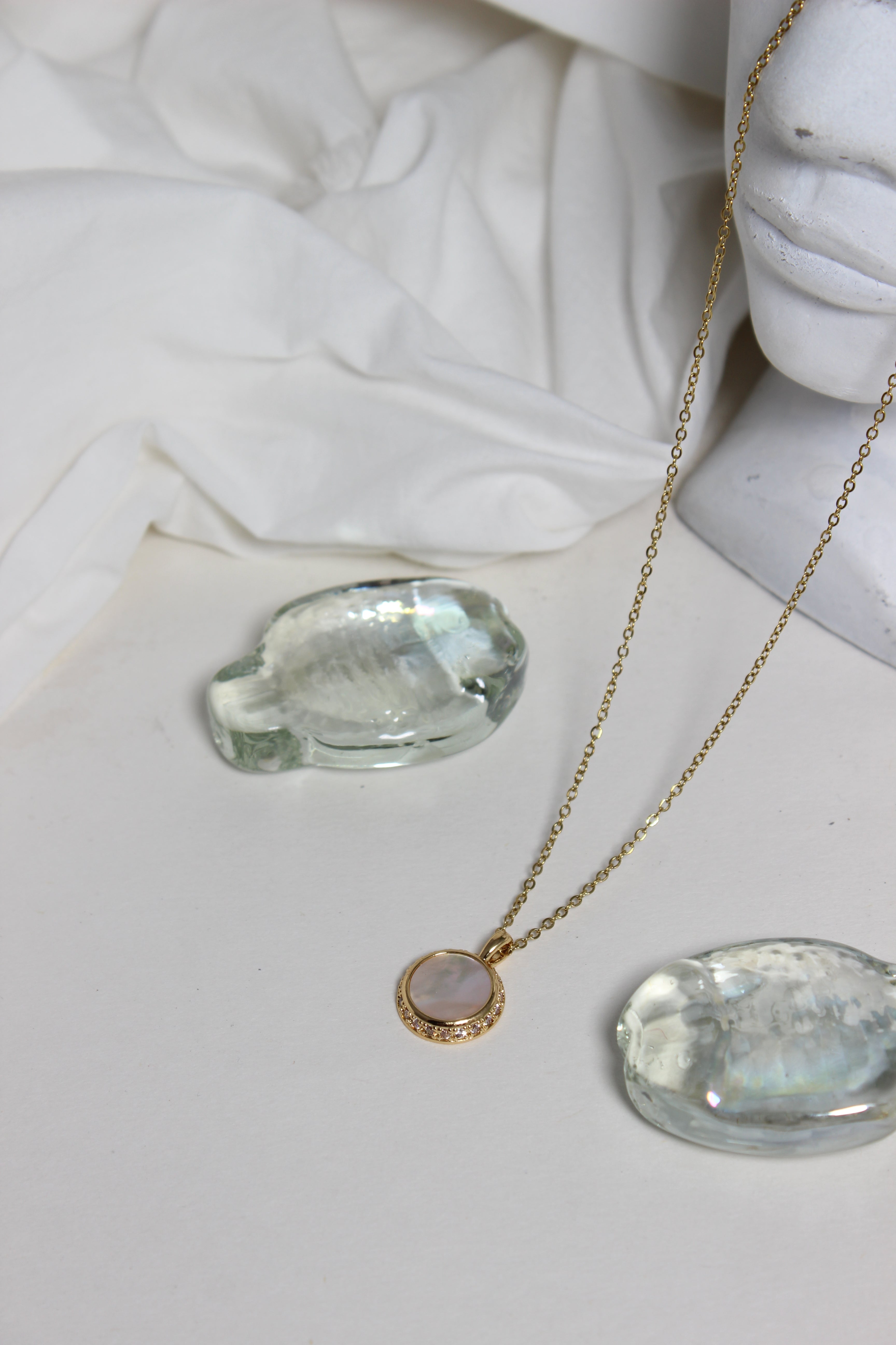 Iridesca Pendant Necklace with a marble bust in the background