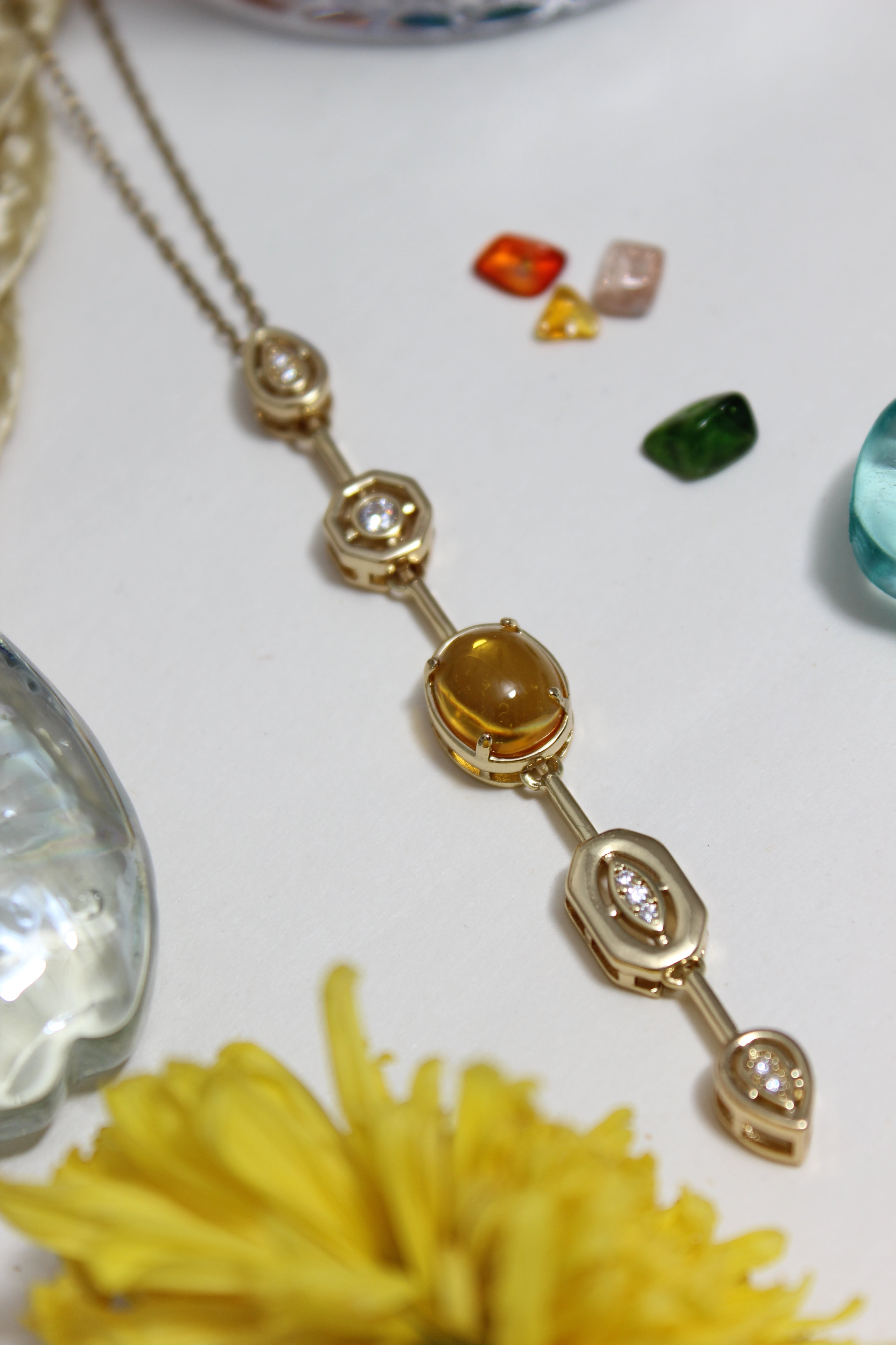 Coralie Necklace on a white surface with flowers