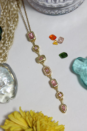 Blush Pastel Pour Necklace on a white surface with decorative seashells