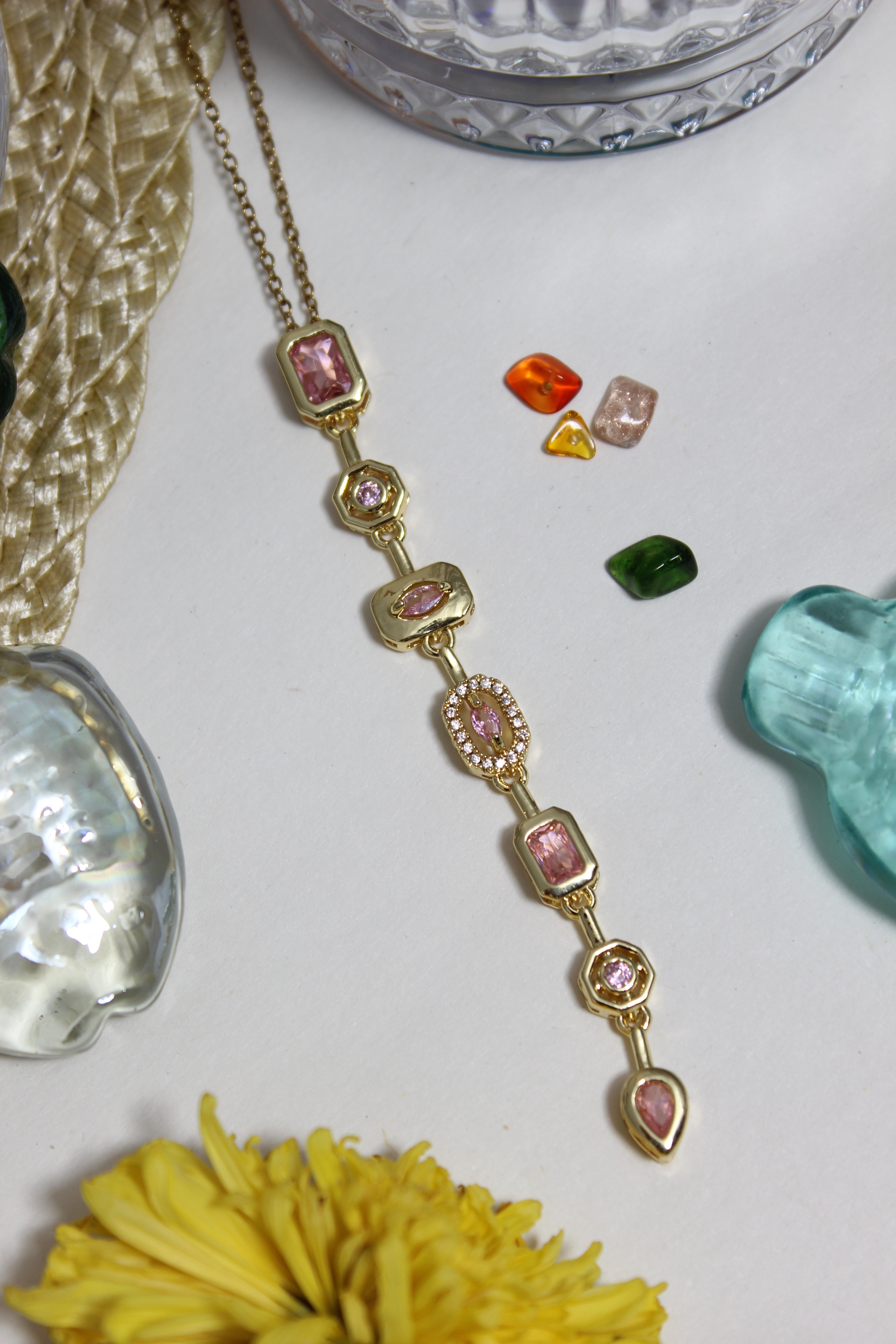 Blush Pastel Pour Necklace on a white surface with decorative seashells