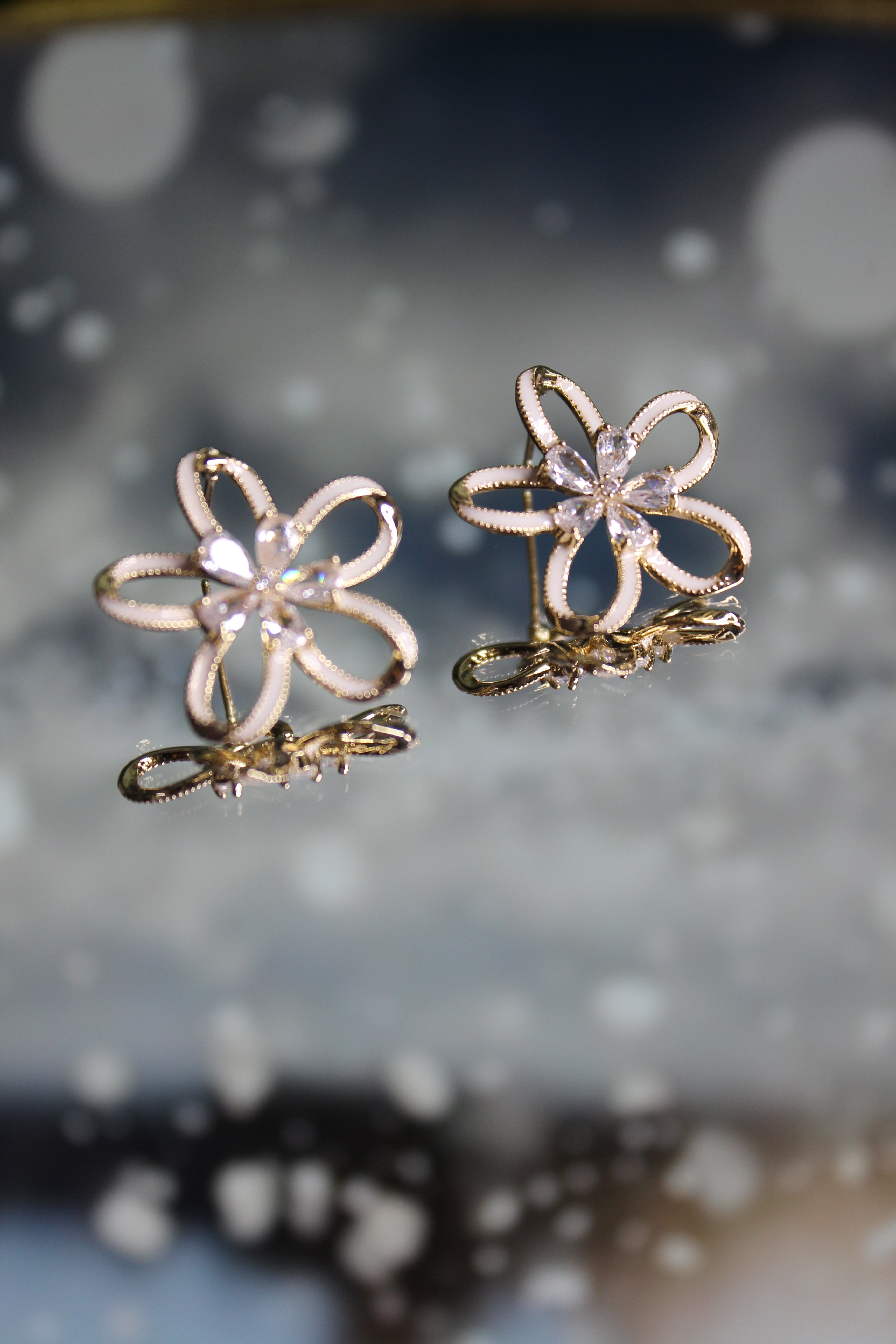 Frost Bloom Stud Earrings on a blurred background