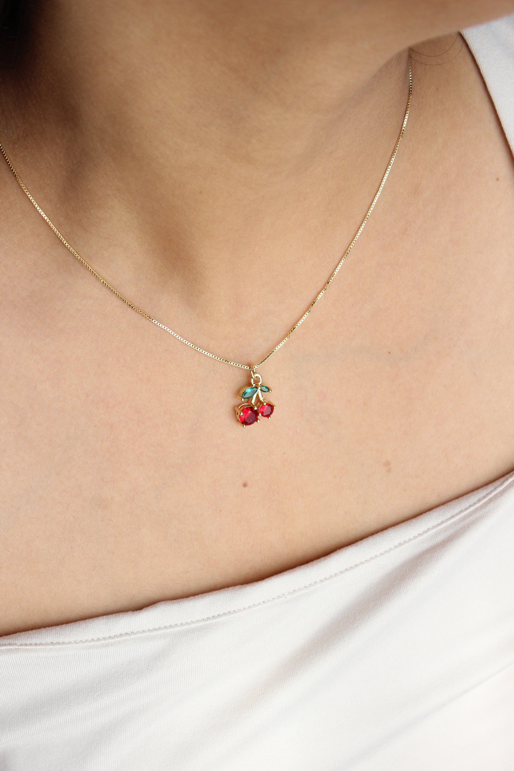 Cherry Glint Pendant Necklace on a person wearing a white top