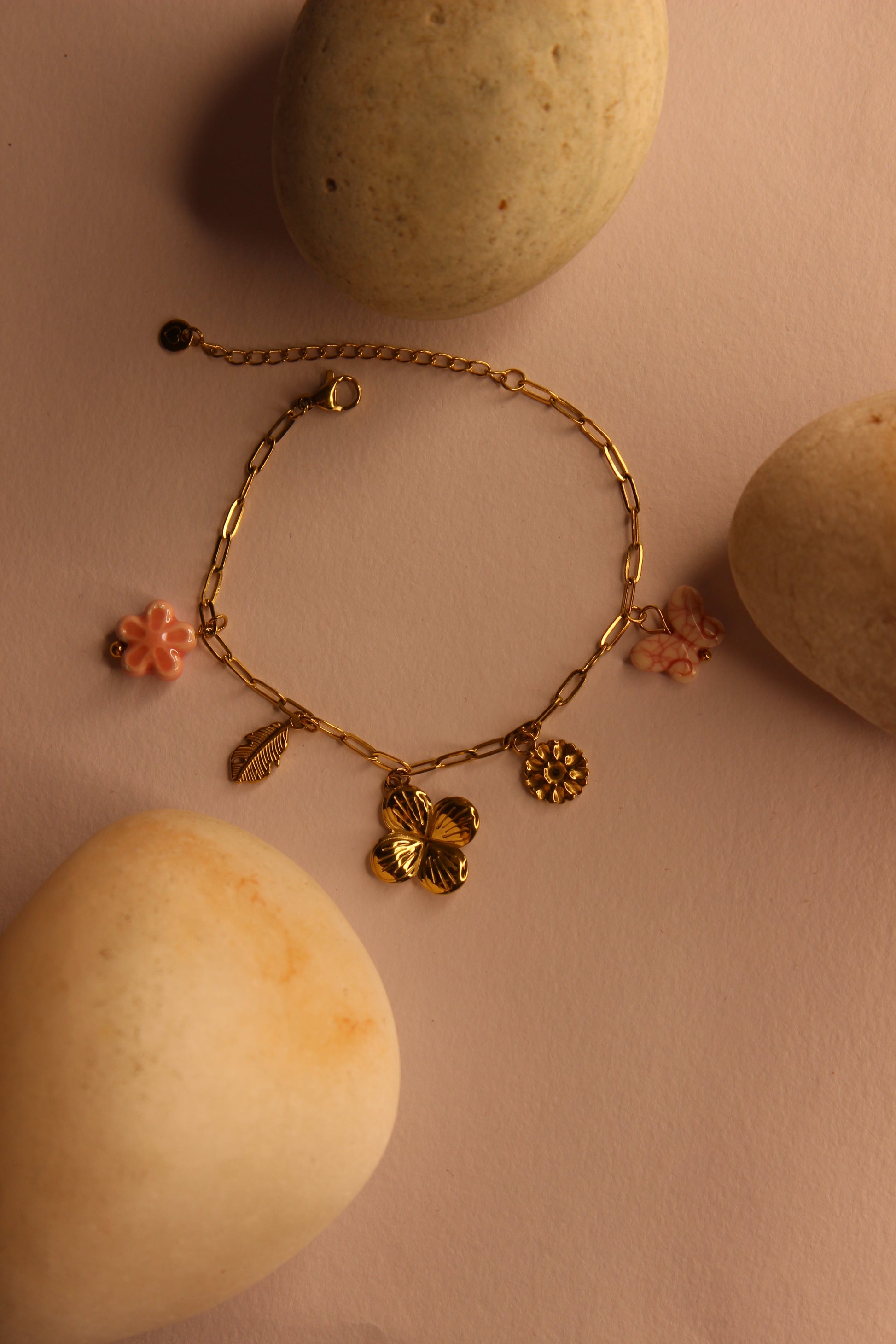 Flutter Bloom Charms Bracelet on a yellow surface with stones