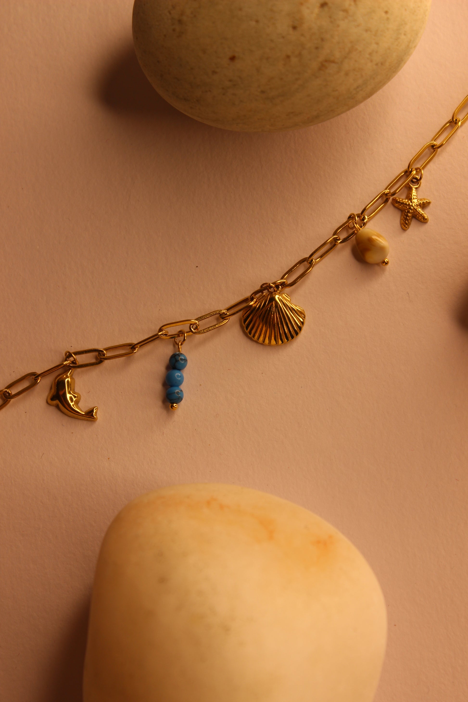 Drifted Charms Bracelet on a pink surface