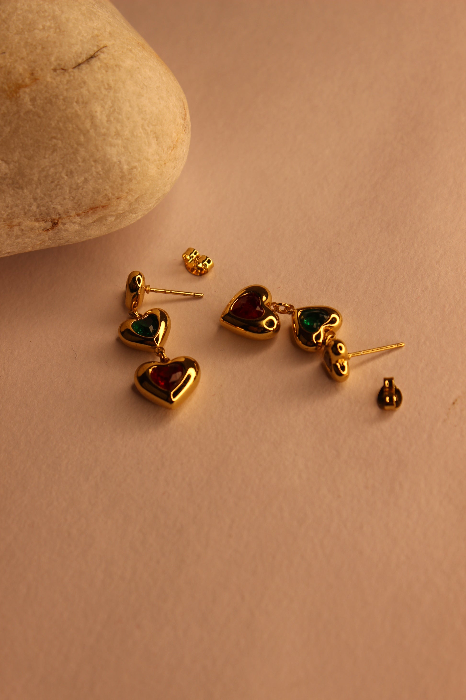 Hearts in Hue Earrings with gemstones on a beige surface
