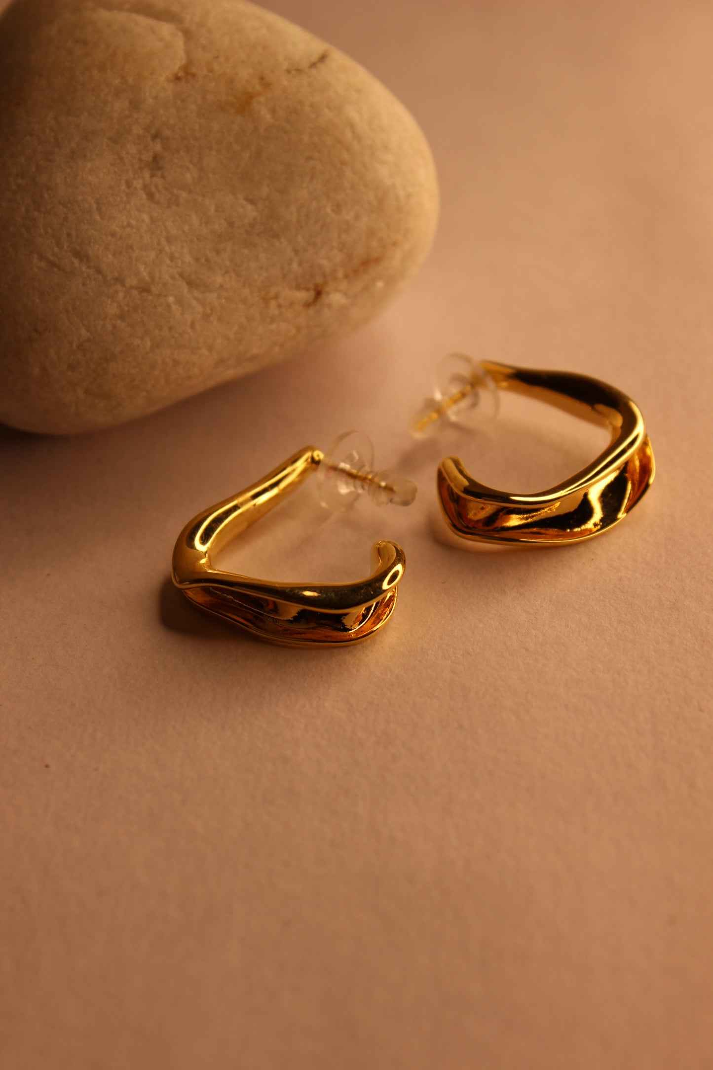 Spinelle Half Hoop Earrings on a beige background