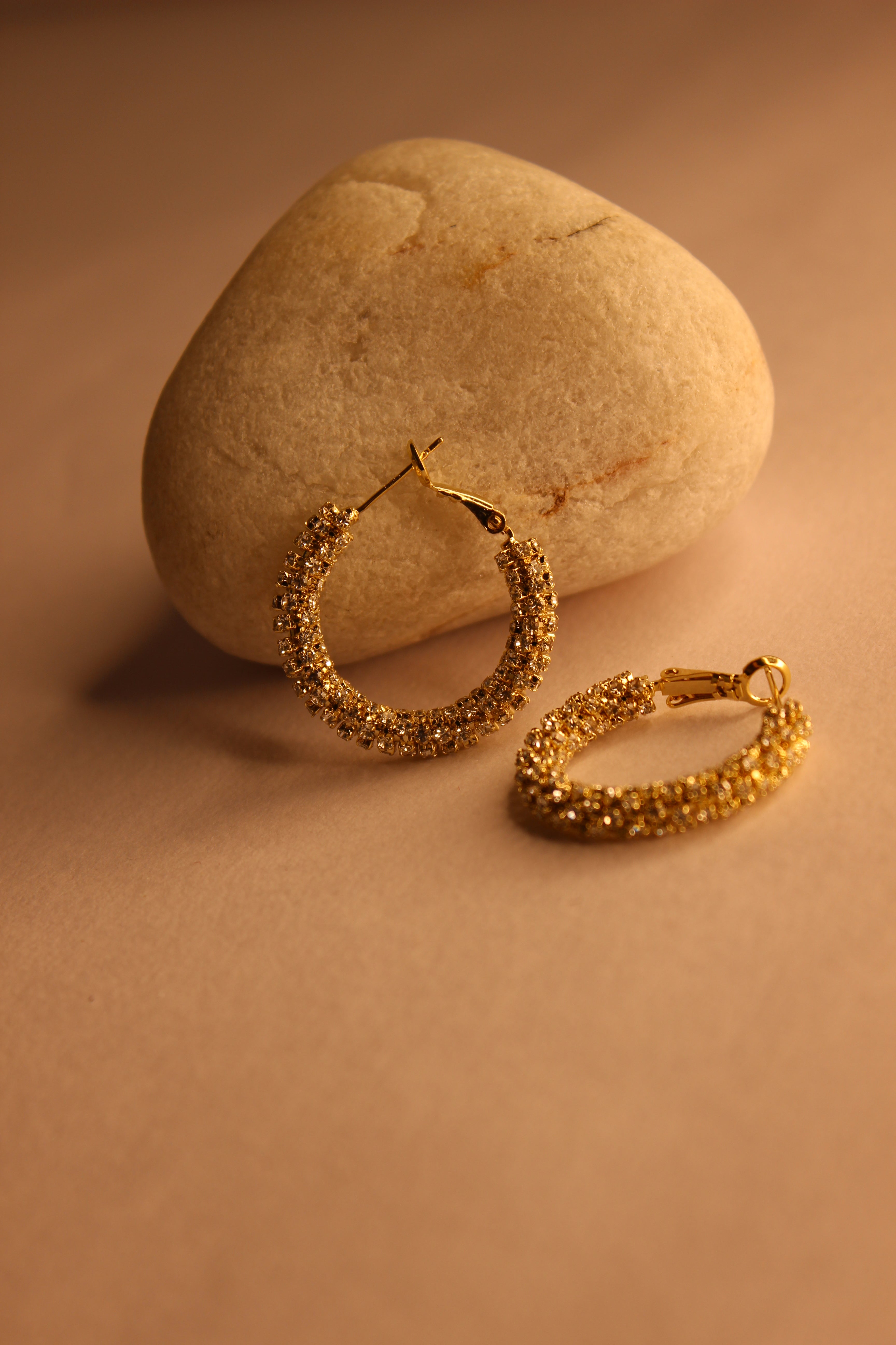 Lumira Hoop Earrings on a stone surface with a warm brown background