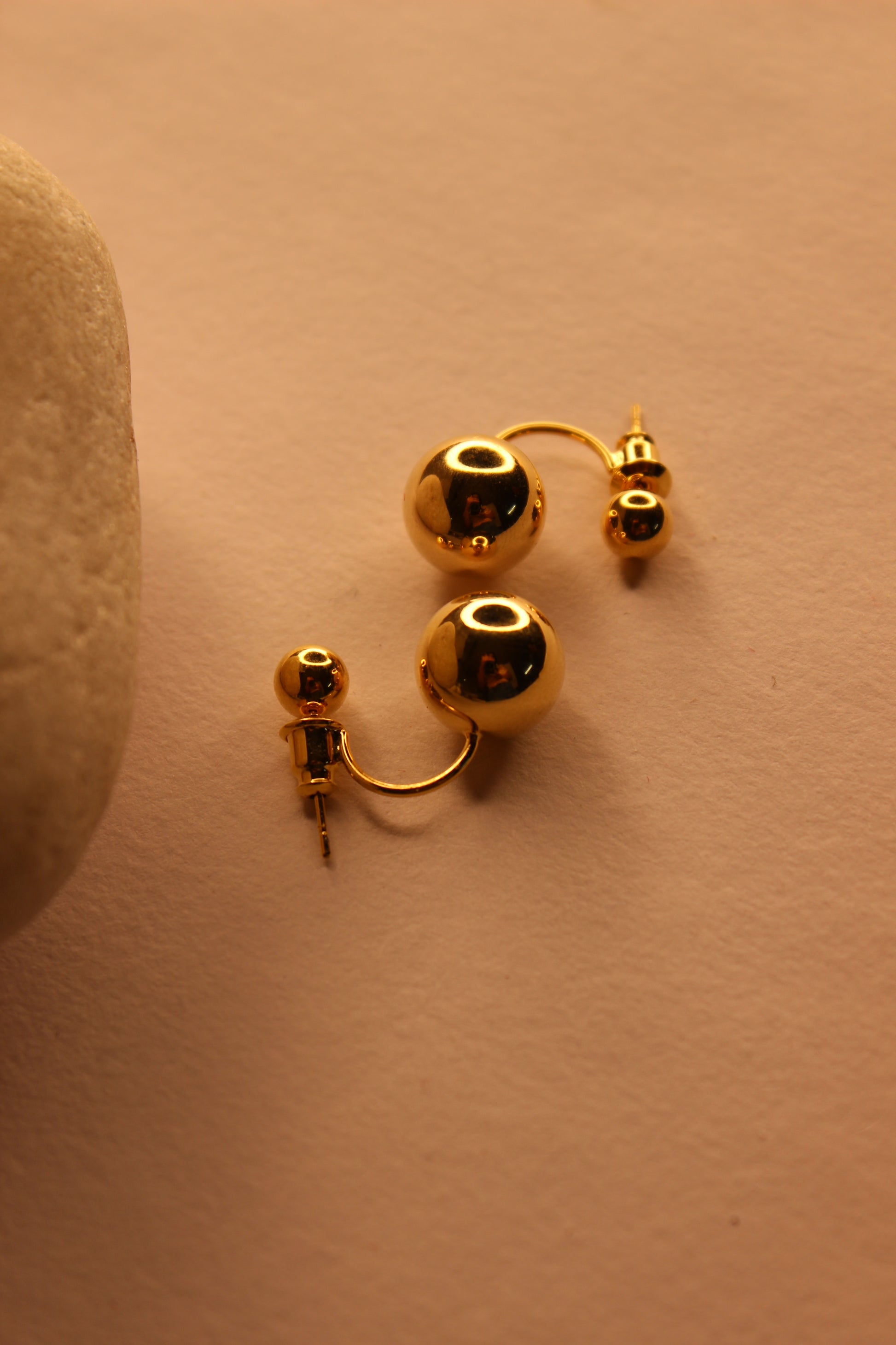 Velisse Stud Earrings on a beige surface