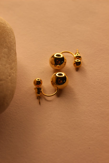 Velisse Stud Earrings on a beige surface