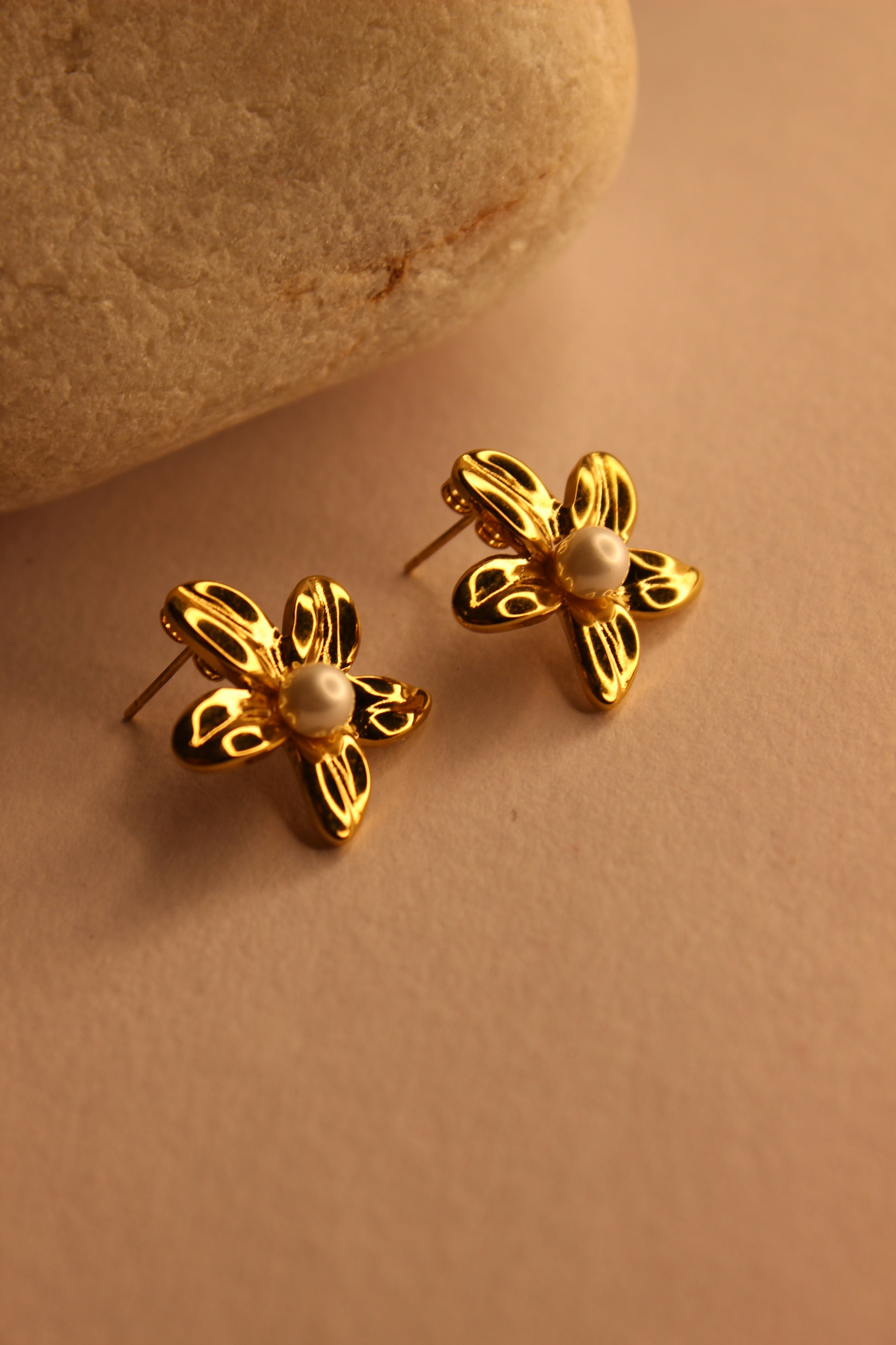 Golden Whisper Stud Earrings on a beige background