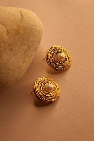 Amara Stud Earrings with pearl centers on a beige background